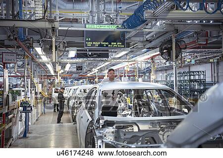 Stock Photo - Workers on car production line in car factory. Fotosearch