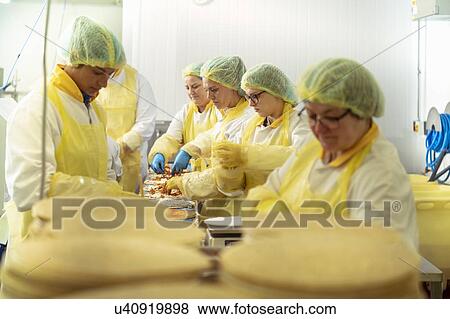 Workers on production line making gluten free pizzas in food factory in food factory View Large Photo Image Stock Photo - Workers on production line making gluten free pizzas in food factory in food factory. Fotosearch