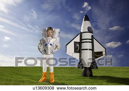 Young astronaut standing next to rocket View Large Photo Image Stock Photo - Young astronaut standing next to rocket. Fotosearch