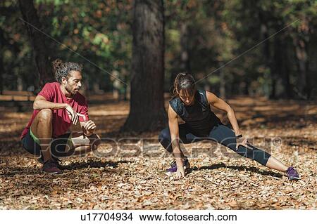 Young couple stretching after training in the park View Large Photo Image Picture - Young couple stretching after training in the park. Fotosearch