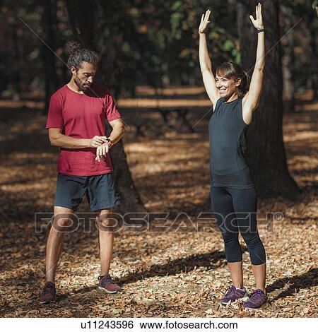 Young couple stretching after training in the park View Large Photo Image Stock Photograph - Young couple stretching after training in the park. Fotosearch