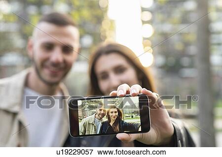 Young couple taking selfie with smartphone in city View Large Photo Image Stock Photo - Young couple taking selfie with smartphone in city. Fotosearch