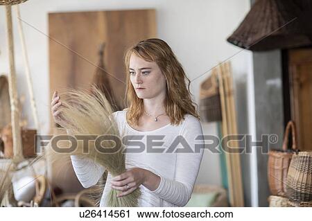 Young female basket maker examining dried grasses in workshop View Large Photo Image Stock Image - Young female basket maker examining dried grasses in workshop. Fotosearch