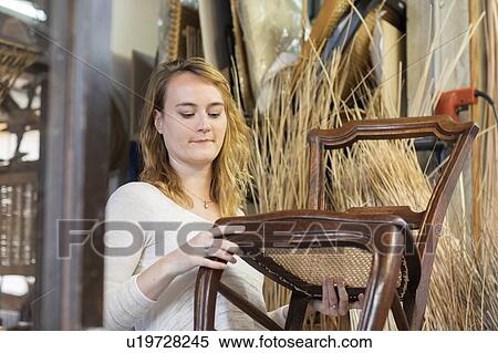 Young female basket maker examining woven seat on dining chair in workshop View Large Photo Image Stock Photography - Young female basket maker examining woven seat on dining chair in workshop. Fotosearch