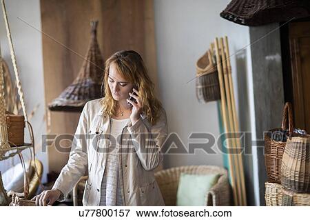 Young female basket maker making smartphone call in workshop View Large Photo Image Stock Photo - Young female basket maker making smartphone call in workshop. Fotosearch