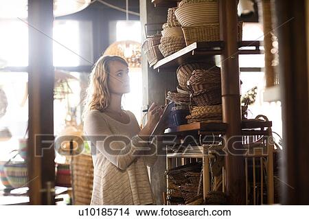 Young female basket maker stock taking in shop View Large Photo Image Picture - Young female basket maker stock taking in shop. Fotosearch