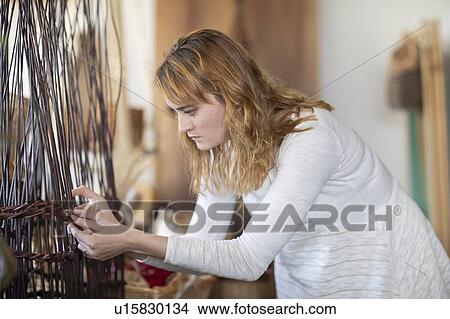 Young female basket maker weaving in workshop View Large Photo Image Picture - Young female basket maker weaving in workshop. Fotosearch