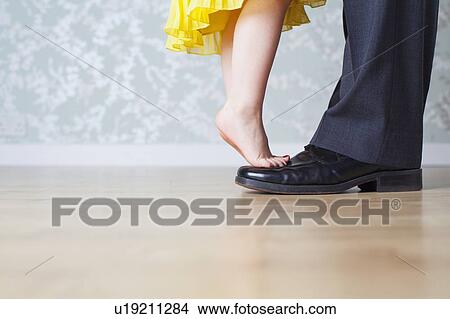 Young girl standing on father's feet View Large Photo Image Picture - Young girl standing on father's feet. Fotosearch
