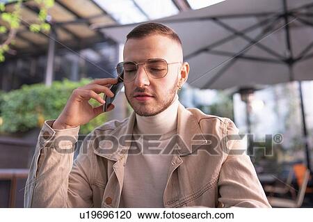 Young man using smartphone at cafe, Milano, Lombardia, Italy View Large Photo Image Stock Image - Young man using smartphone at cafe, Milano, Lombardia, Italy. Fotosearch