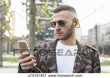 Young man using smartphone in city, Milano, Lombardia, Italy View Large Photo Image Stock Photo - Young man using smartphone in city, Milano, Lombardia, Italy. Fotosearch