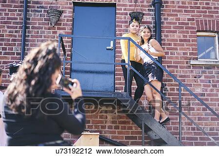 Young woman and her teenage sister being photographed on fire escape View Large Photo Image Stock Image - Young woman and her teenage sister being photographed on fire escape. Fotosearch