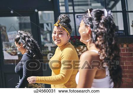 Young woman and her teenage sisters walking and talking on street View Large Photo Image Stock Image - Young woman and her teenage sisters walking and talking on street. Fotosearch