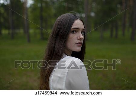 Picture - Young woman by forest. Fotosearch