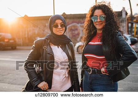 Young woman in hijab and best friend in city at sunset, portrait View Large Photo Image Stock Image - Young woman in hijab and best friend in city at sunset, portrait. Fotosearch