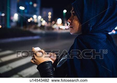 Young woman in hijab at pedestrian crossing in city at night View Large Photo Image Stock Image - Young woman in hijab at pedestrian crossing in city at night. Fotosearch
