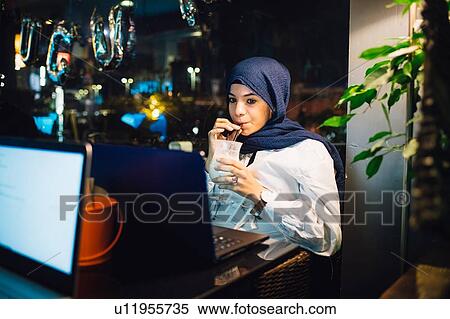 Young woman in hijab drinking smoothie in cafe View Large Photo Image Stock Photography - Young woman in hijab drinking smoothie in cafe. Fotosearch