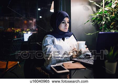 Young woman in hijab looking at laptop in cafe View Large Photo Image Stock Photography - Young woman in hijab looking at laptop in cafe. Fotosearch