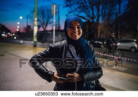 Young woman in hijab on city sidewalk at night, portrait View Large Photo Image Stock Image - Young woman in hijab on city sidewalk at night, portrait. Fotosearch
