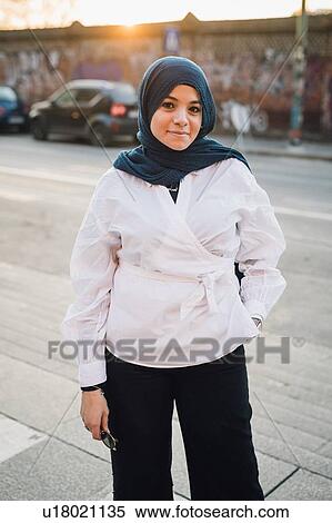 Young woman in hijab on city sidewalk, portrait View Large Photo Image Stock Photography - Young woman in hijab on city sidewalk, portrait. Fotosearch