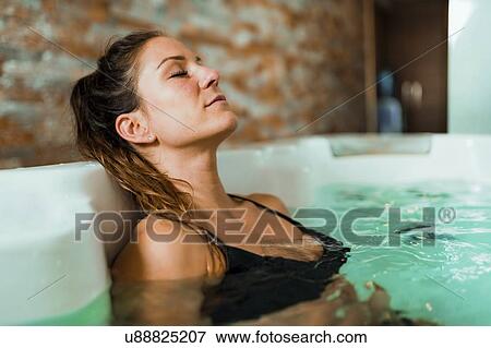 Stock Photo - Young woman in hot tub. Fotosearch