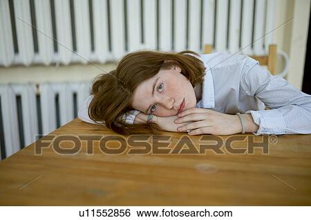 Young woman leaning on wooden table View Large Photo Image Stock Photograph - Young woman leaning on wooden table. Fotosearch