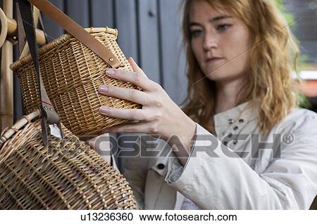 Young woman looking at wickerwork basket in shop View Large Photo Image Stock Image - Young woman looking at wickerwork basket in shop. Fotosearch