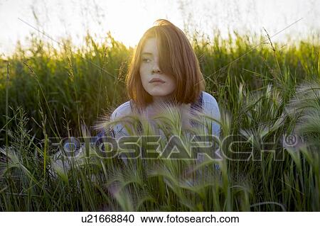 Young woman lying in wheat field View Large Photo Image Stock Image - Young woman lying in wheat field. Fotosearch