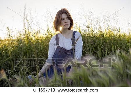 Young woman sitting in wheat field View Large Photo Image Stock Image - Young woman sitting in wheat field. Fotosearch