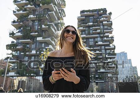 Stock Photo - Young woman using digital tablet in city, Milano, Lombardia, Italy. Fotosearch