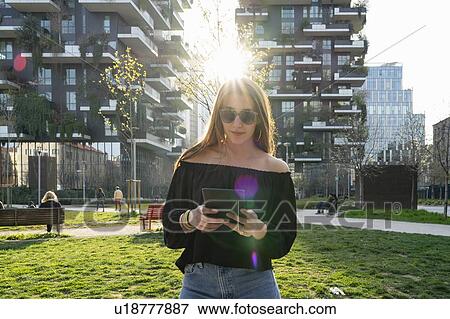 Young woman using digital tablet in city, Milano, Lombardia, Italy View Large Photo Image Stock Photo - Young woman using digital tablet in city, Milano, Lombardia, Italy. Fotosearch