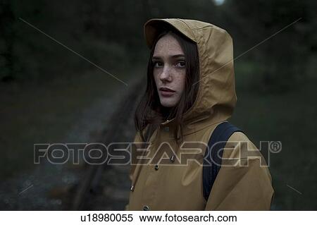 Stock Photography - Young woman wearing brown raincoat. Fotosearch