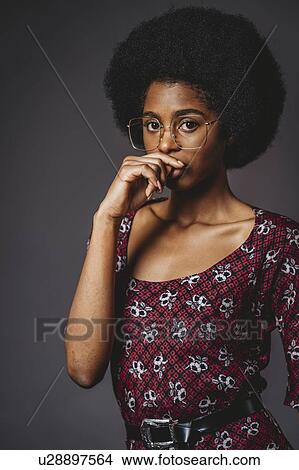 Young woman with afro hair against grey background View Large Photo Image Picture - Young woman with afro hair against grey background. Fotosearch