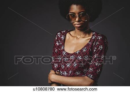 Young woman with afro hair against grey background View Large Photo Image Stock Image - Young woman with afro hair against grey background. Fotosearch
