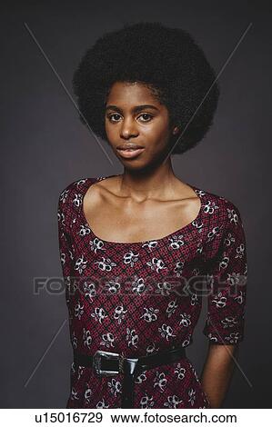 Young woman with afro hair against grey background View Large Photo Image Stock Photo - Young woman with afro hair against grey background. Fotosearch