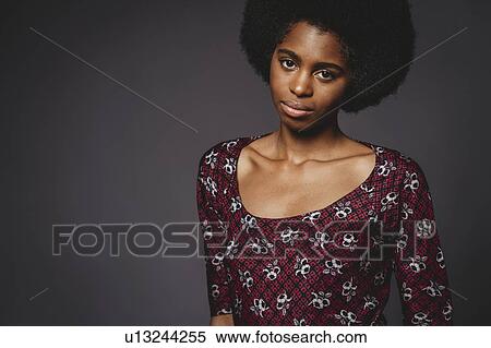 Young woman with afro hair against grey background View Large Photo Image Stock Photography - Young woman with afro hair against grey background. Fotosearch
