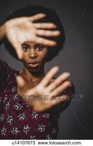 Young woman with afro hair covering face with hands, grey background View Large Photo Image Stock Image - Young woman with afro hair covering face with hands, grey background. Fotosearch