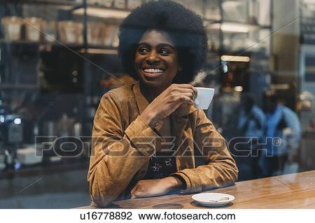 Young woman with afro hair having coffee in cafe View Large Photo Image Stock Image - Young woman with afro hair having coffee in cafe. Fotosearch