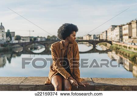 Young woman with afro hair smoking on bridge, Florence, Toscana, Italy View Large Photo Image Picture - Young woman with afro hair smoking on bridge, Florence, Toscana, Italy. Fotosearch