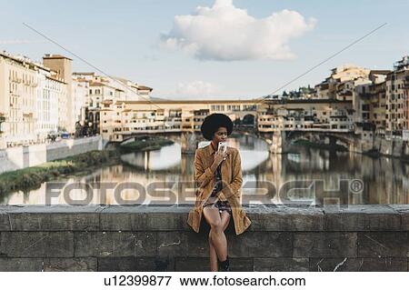 Young woman with afro hair waiting on bridge, Florence, Toscana, Italy View Large Photo Image Stock Photo - Young woman with afro hair waiting on bridge, Florence, Toscana, Italy. Fotosearch