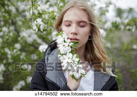 Young woman with her eyes closed holding white blossoms View Large Photo Image Stock Image - Young woman with her eyes closed holding white blossoms. Fotosearch