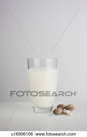 Stock Photograph - A glass of fresh almond milk with almonds. Fotosearch
