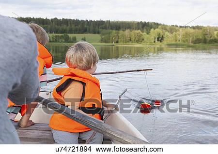 Picture - Adult sailing with boys on boat in lake, Finland. Fotosearch