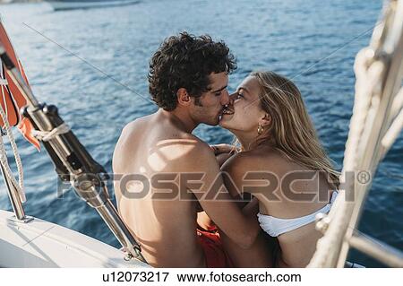 Stock Photo - Affectionate couple on sailboat, Italy. Fotosearch