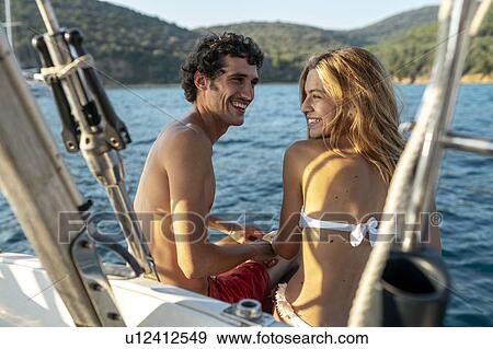 Stock Photo - Affectionate couple on sailboat, Italy. Fotosearch