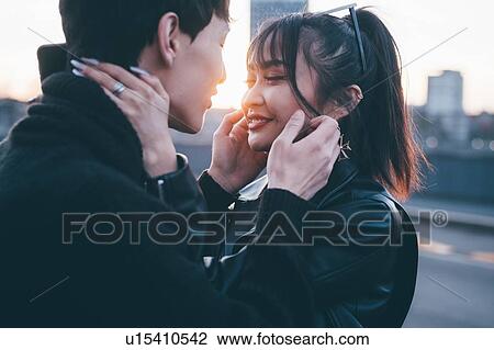 Stock Image - Affectionate young couple on street, Milan, Italy. Fotosearch