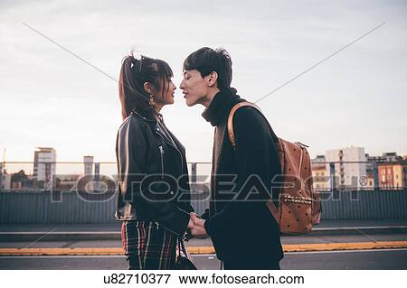 Stock Photo - Affectionate young couple on street, Milan, Italy. Fotosearch