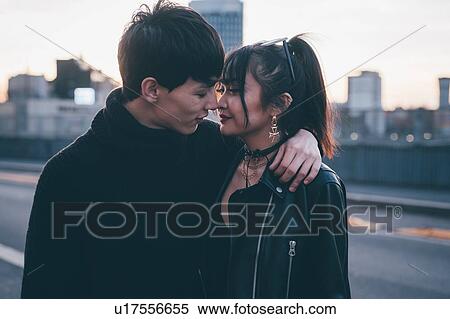 Stock Photography - Affectionate young couple on street, Milan, Italy. Fotosearch
