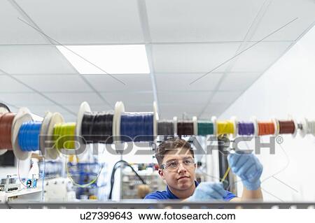 Apprentice electrical engineer selecting wire on production line in medical scientific factory View Large Photo Image Stock Image - Apprentice electrical engineer selecting wire on production line in medical scientific factory. Fotosearch