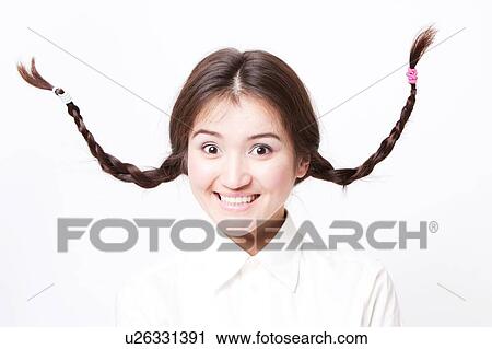 Asian girl pulling funny face with pigtails going up in the air View Large Photo Image Stock Image - Asian girl pulling funny face with pigtails going up in the air. Fotosearch