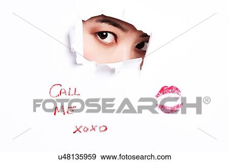 Stock Photo - Asian woman pearing through ripped paper. Fotosearch